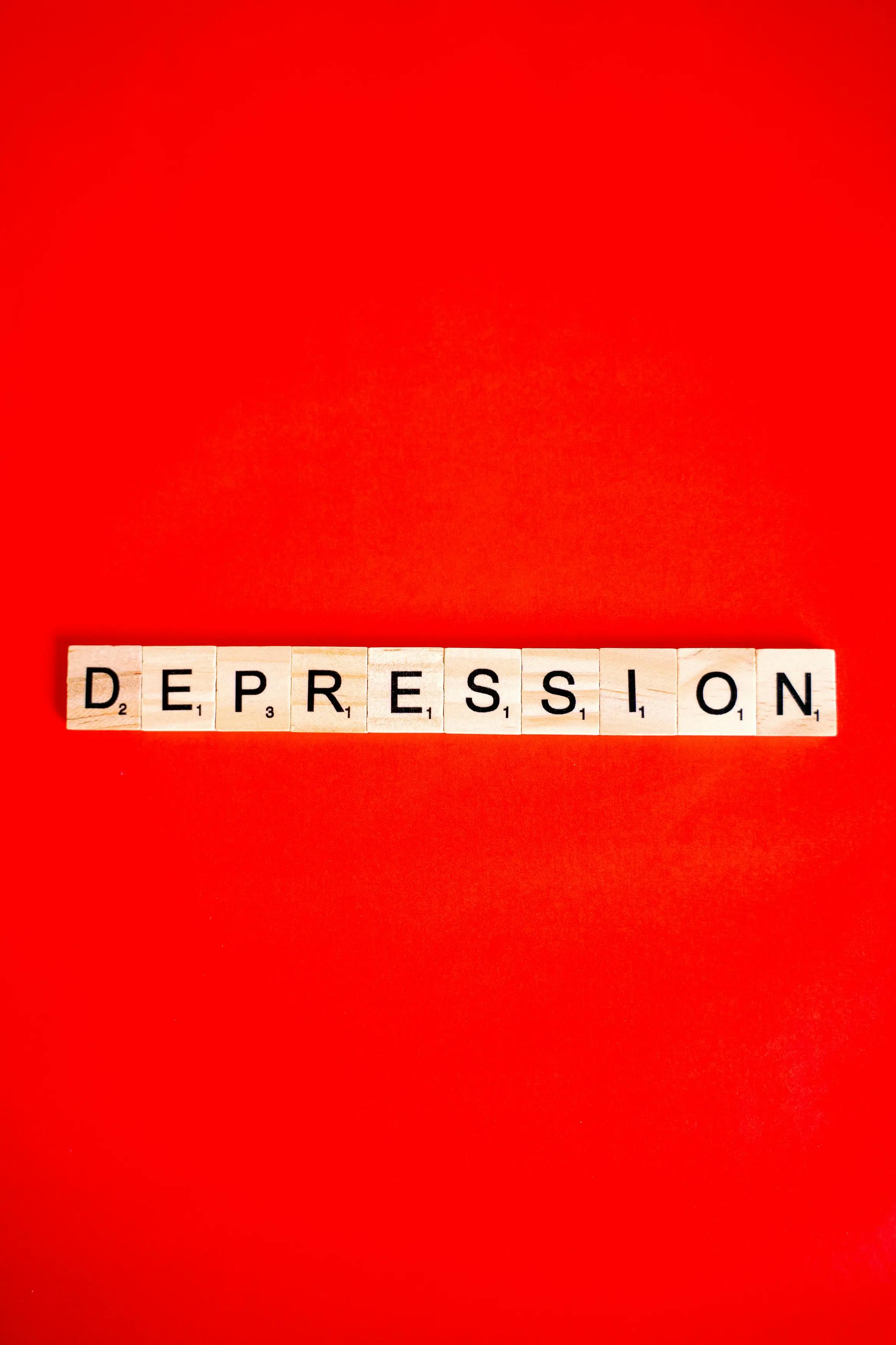 Buchstaben Depression aus Holzsteinen auf rotem Untergrund