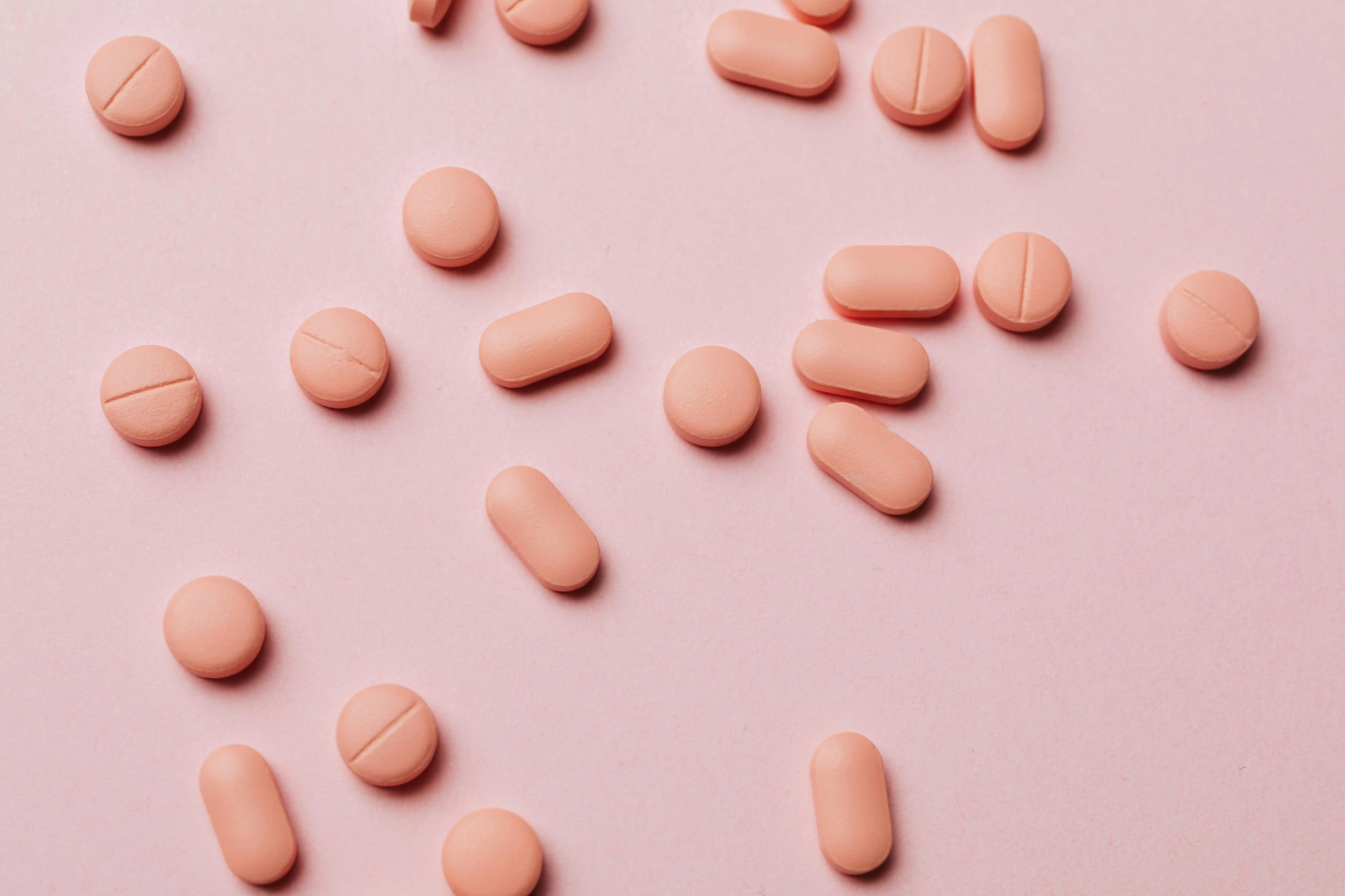 rosa Tabletten auf rosa Untergrund Vitamine gegen Altern