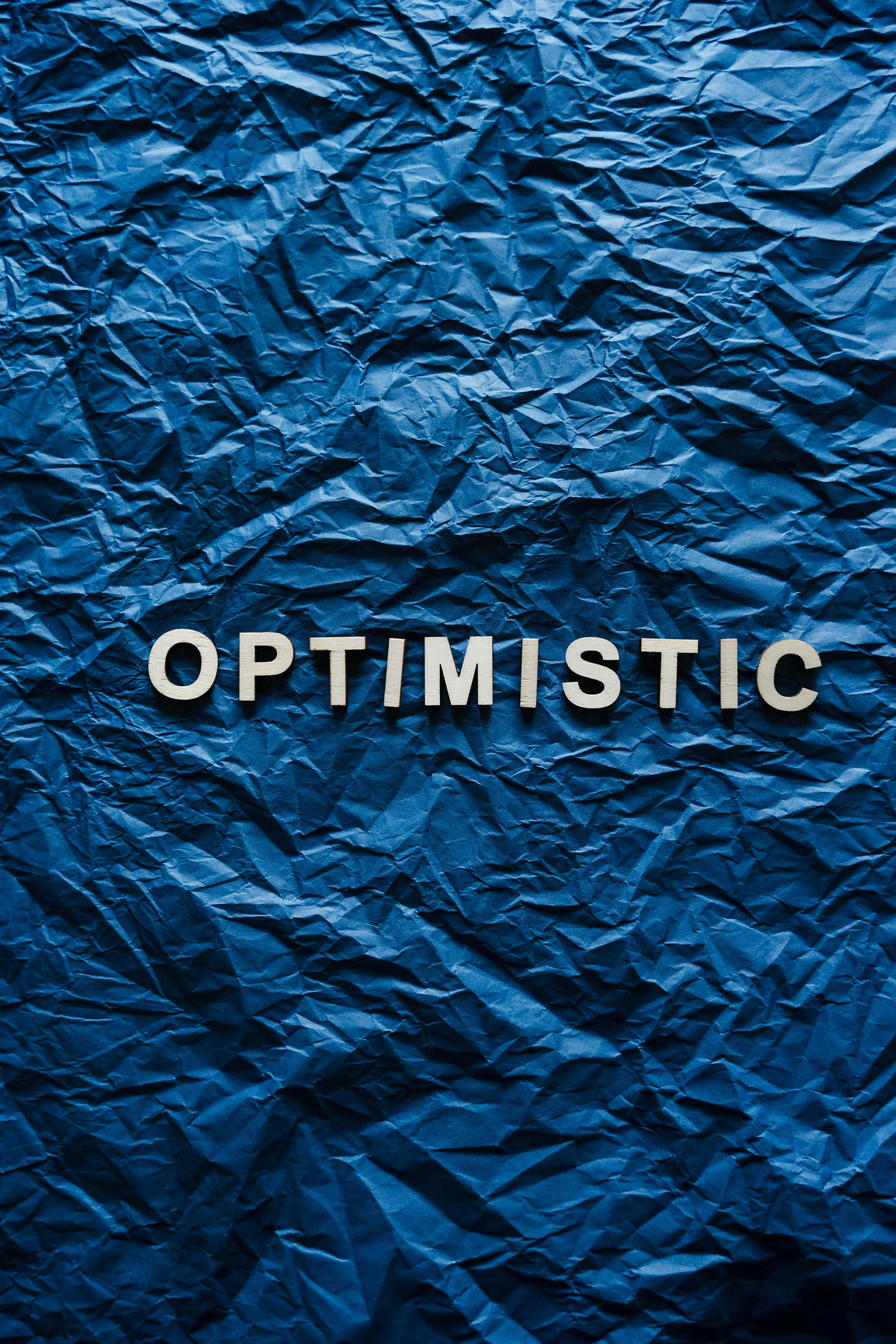 Schriftzug Optimistic auf blauem Untergrund