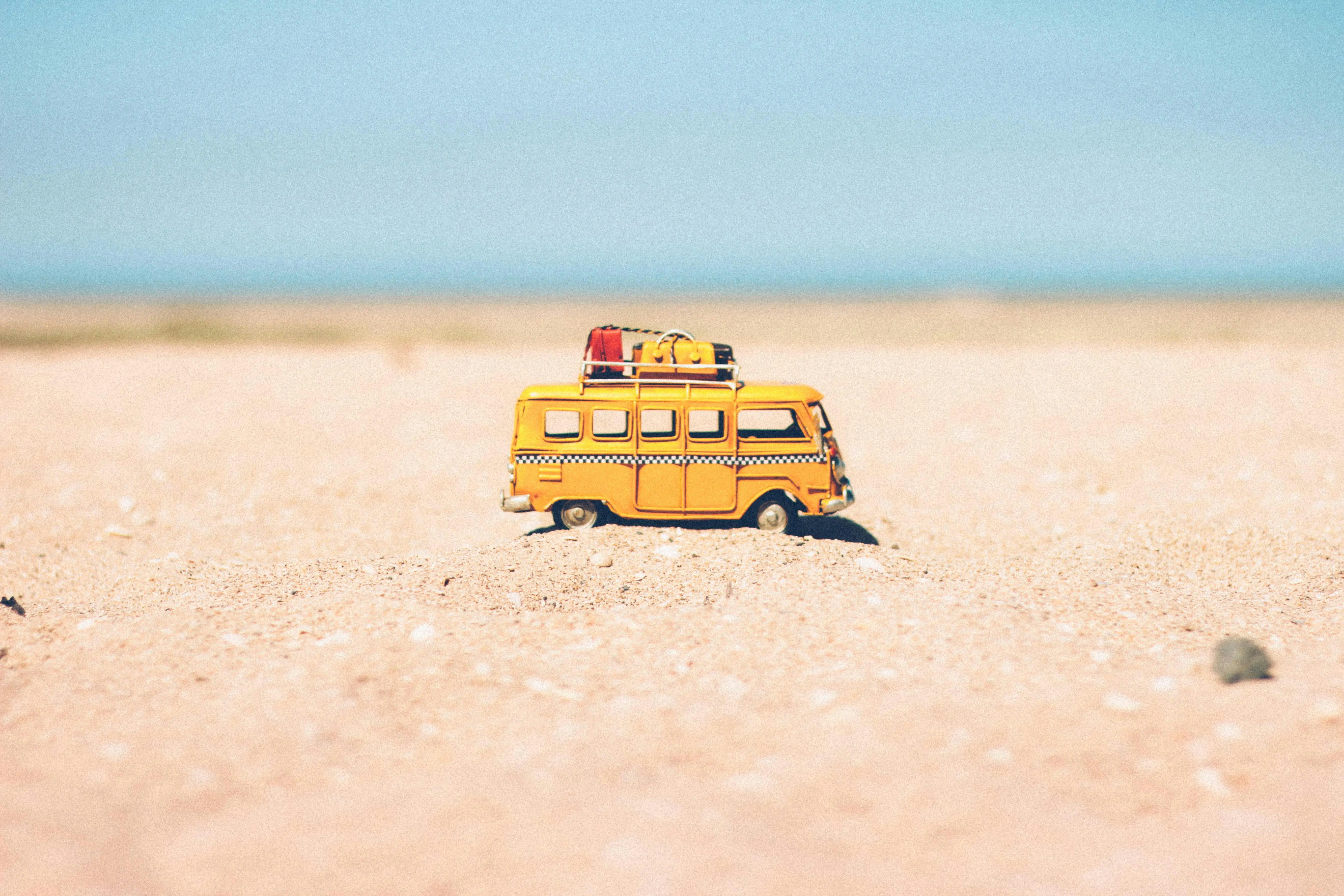 kleiner gelber Bus fährt im Sand